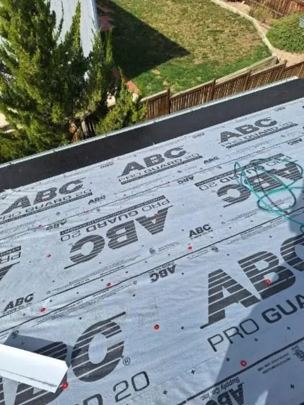Flat roof replacement in progress on a commercial building with underlayment installed